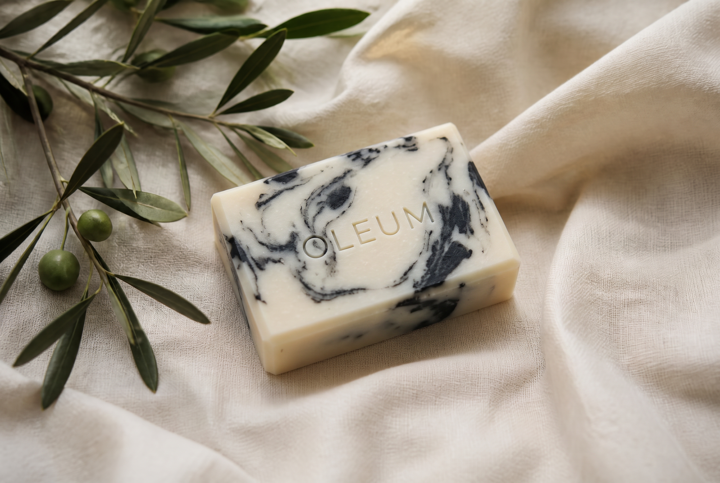 Handmade natural soap on travertine stone with olive branches